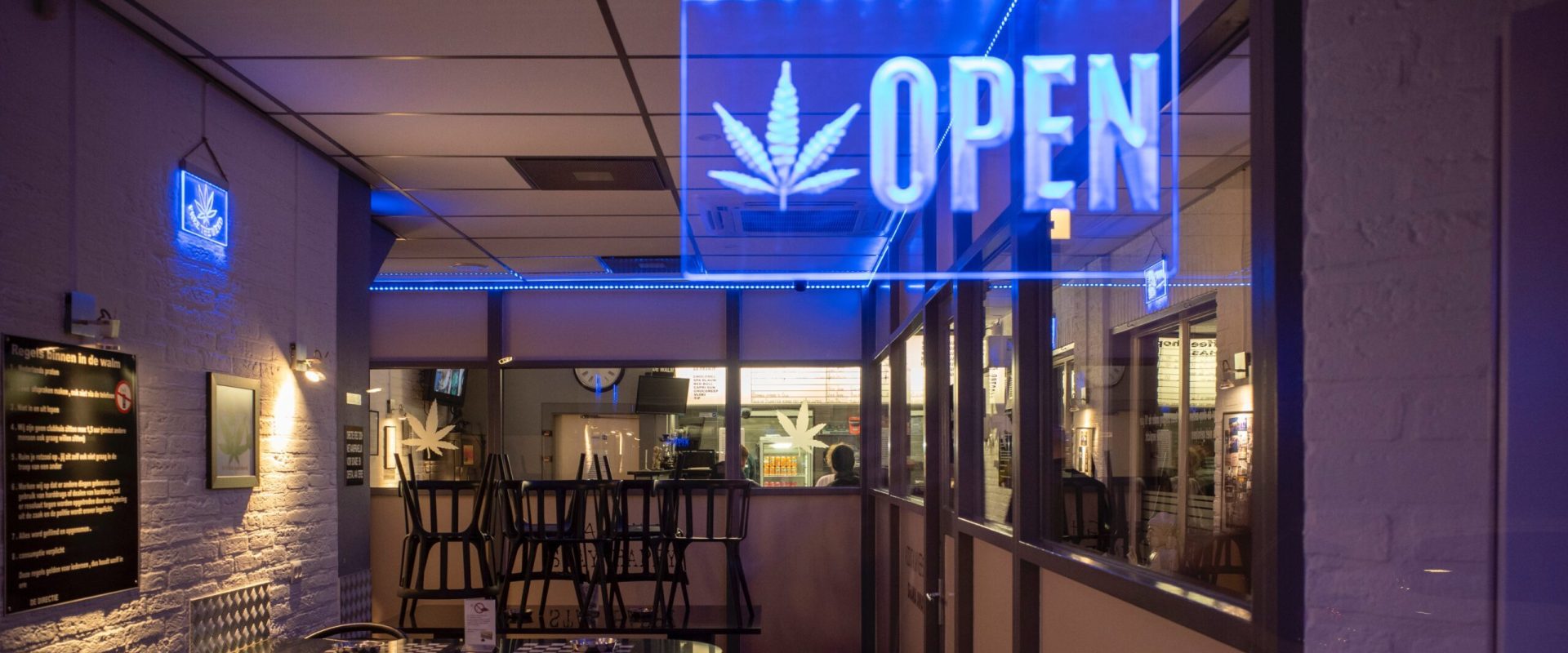 Inside of a Social Club, with neon "open" shield